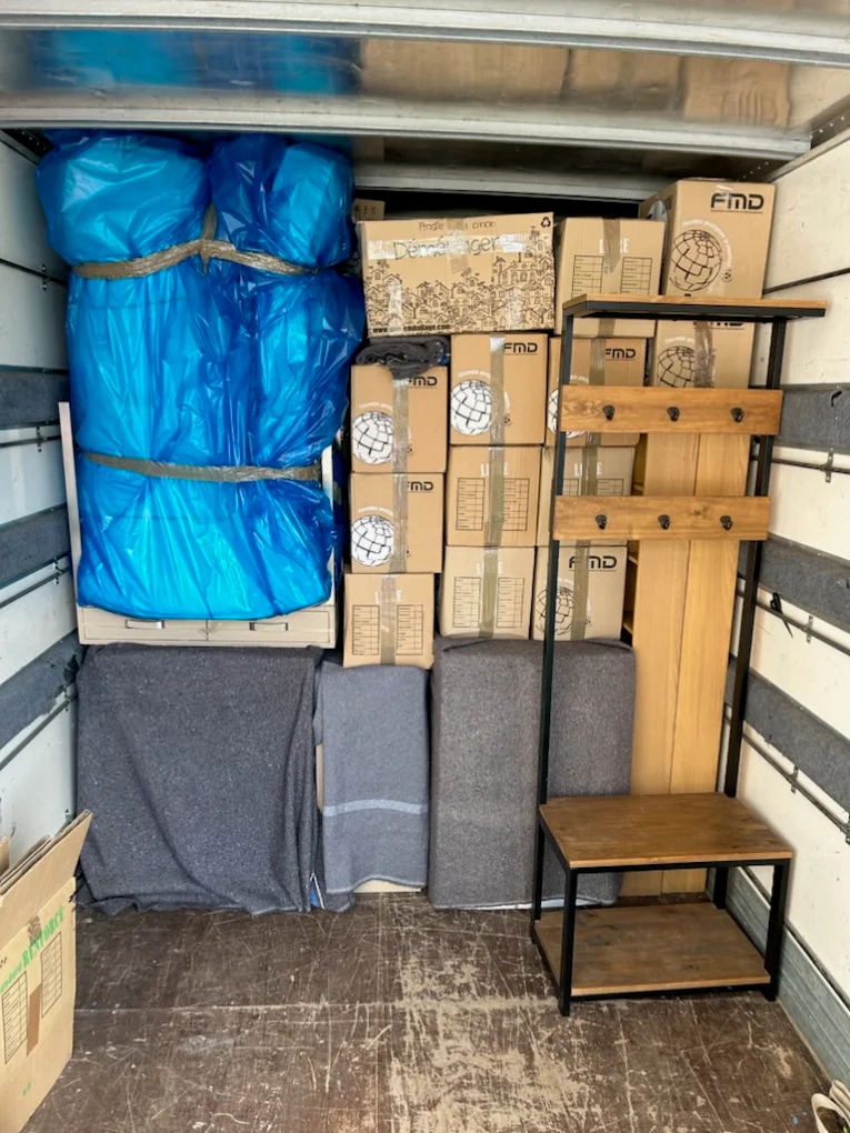 Cartons de déménagement étiquetés et meubles protégés par des couvertures dans le camion AXLR Transports